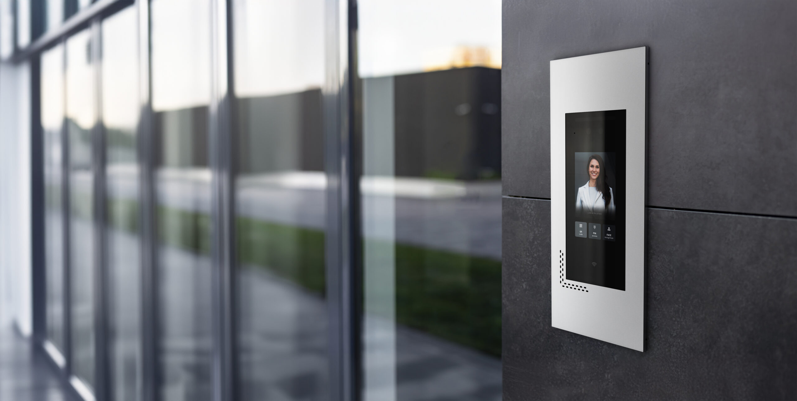 Entrance doorbell in a multi-apartment building, with a video surveillance camera, on a dark wall.